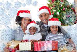 Composite image of family holding christmas presents