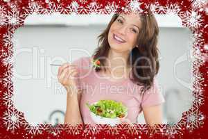 Portrait of smiling woman with a bowl of salad in kitchen