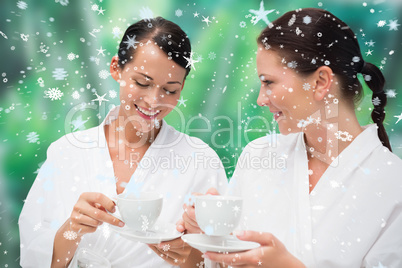 Beautiful friends in bathrobes drinking herbal tea