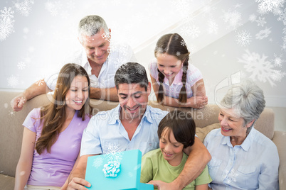 Composite image of man opening birthday present at home