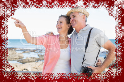 Happy casual couple looking at something by the coast