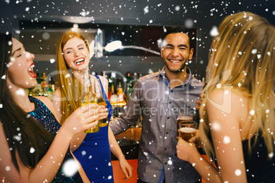 Composite image of laughing friends drinking beers