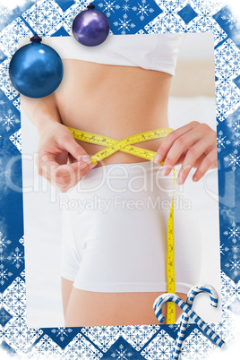 Composite image of toned woman measuring her waist
