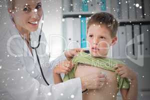 Composite image of confident doctor examining boy with stethosco