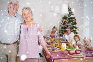 Composite image of grandparents standing by the dinner table