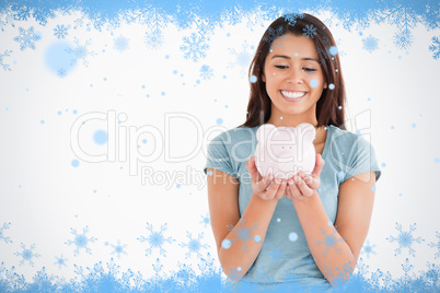 Attractive woman posing with a piggy bank