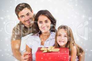 Composite image of parents offering a gift to their daughter