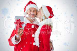 Festive couple embracing and holding gift