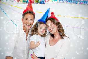 Portrait of cute little girl with her parents during a birthday
