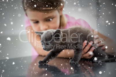 Composite image of girl playing with kitten