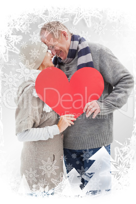 Composite image of happy mature couple in winter clothes holding