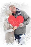 Composite image of happy mature couple in winter clothes holding