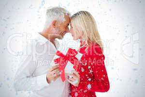 Smiling couple passing a wrapped gift