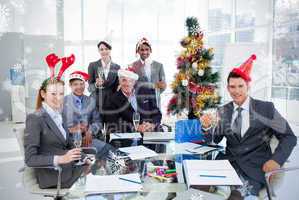 Portrait of a smiling business team wearing novelty christmas ha