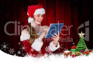Composite image of pretty santa girl using tablet pc