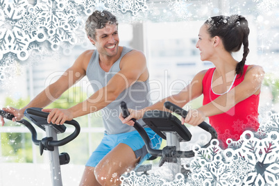 Smiling couple working out at spinning class