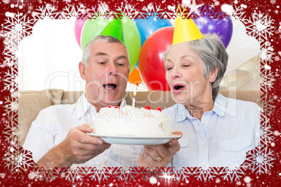 Senior couple sitting on couch celebrating a birthday