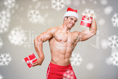 Shirtless macho man in santa hat holding gifts