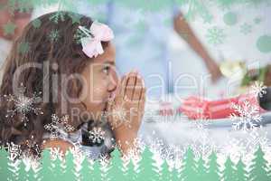 Composite image of little girl sitting praying at table
