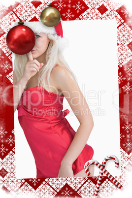 Young woman wearing santa hat with finger on lips