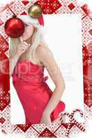 Young woman wearing santa hat with finger on lips