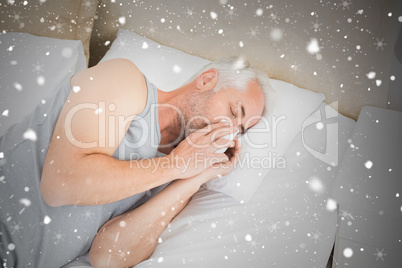 High angle view of a man suffering from cold in bed