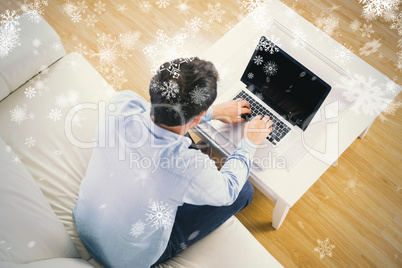 Composite image of high angle view of casual man typing on lapto