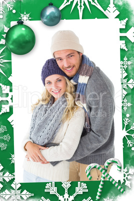 Composite image of attractive couple in winter fashion hugging Composite image of attractive couple in winter fashion hugging