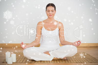 Smiling brunette sitting in lotus pose looking at camera