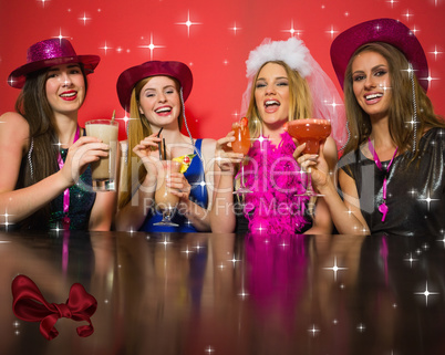 Composite image of laughing friends having hen party holding coc