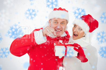 Festive couple smiling and holding gift