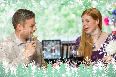 Composite image of cheerful couple eating together