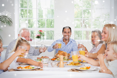 Composite image of family toasting at thanksgiving