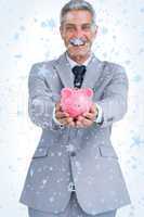 Composite image of wide smiling businessman holding piggy bank