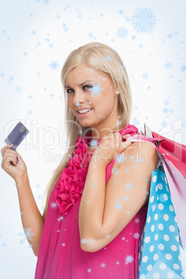 Composite image of blonde holding shopping bags and a card