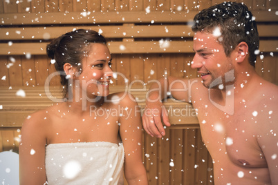 Smiling couple relaxing in a sauna and chatting