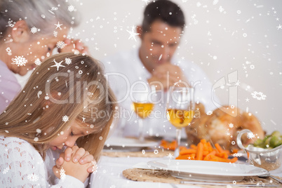 Composite image of little girl saying grace with family