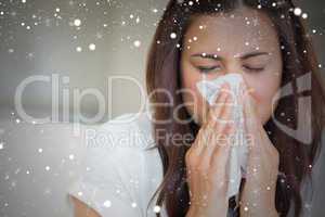 Composite image of brunette blowing nose into tissue