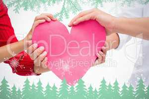 Composite image of couples hands holding pink heart