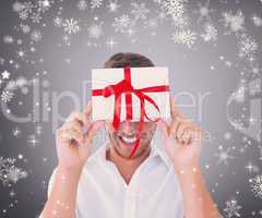 Composite image of man holding gift