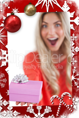Composite image of astonished woman holding a gift