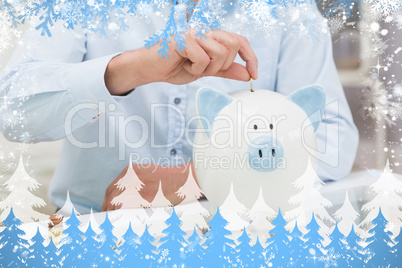 Mid section of a man putting some coins into a piggy bank