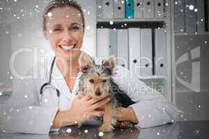 Happy female veterinarian holding puppy