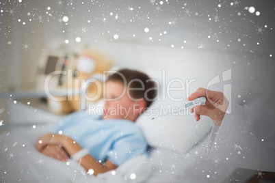 Doctor holding thermometer with boy in hospital