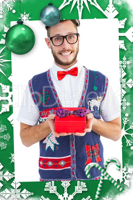 Composite image of geeky hipster offering christmas gift