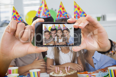 Composite image of hand holding smartphone showing