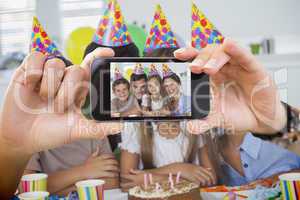 Composite image of hand holding smartphone showing