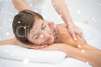 Attractive young woman receiving shoulder massage at spa center