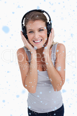 Composite image of portrait of a smiling woman listening to musi