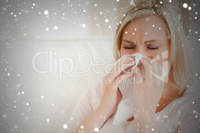 Composite image of ill woman blowing her nose